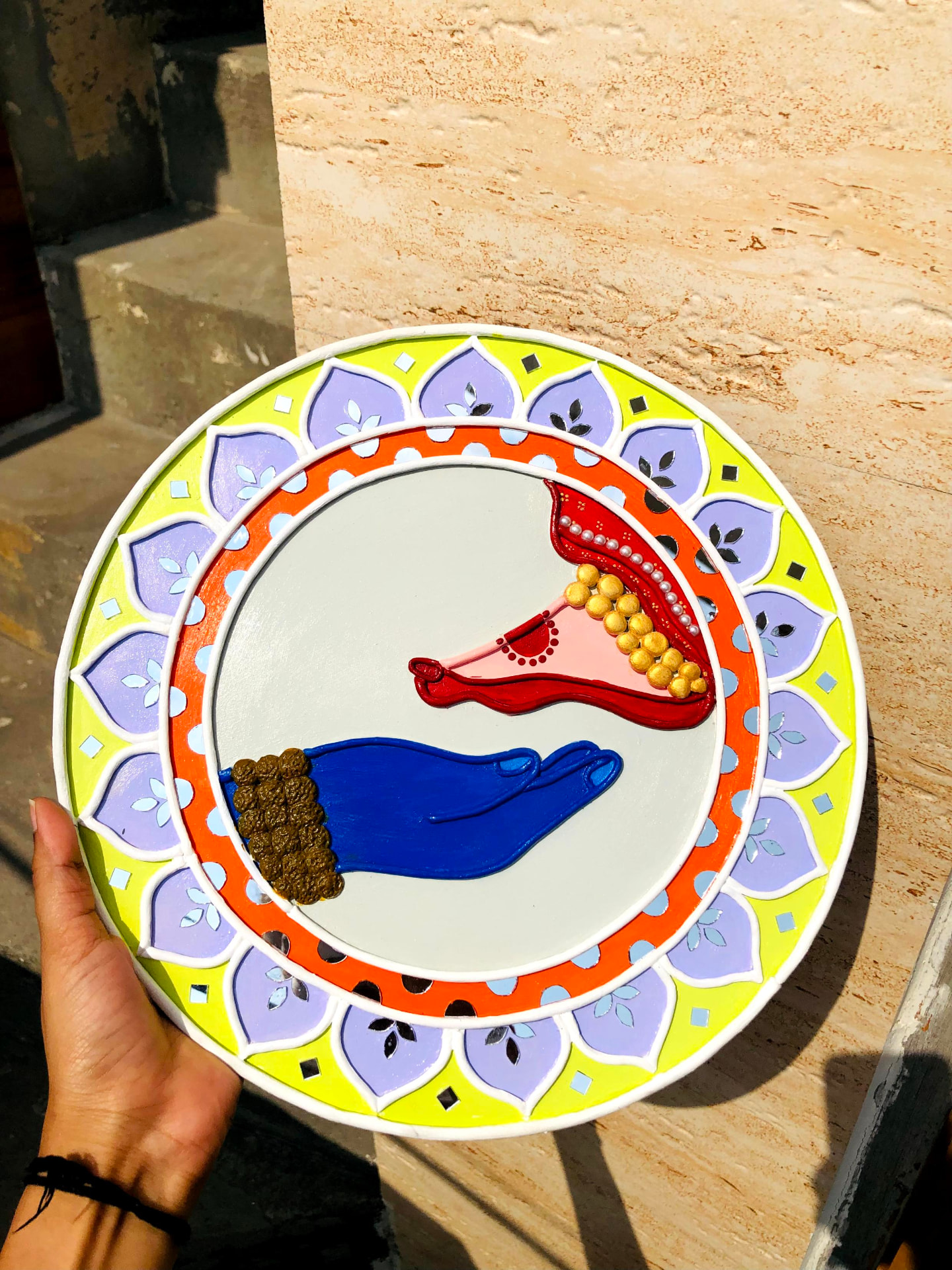 Raised mud lines, dots, and mirrors in a colorful handcrafted diya artwork